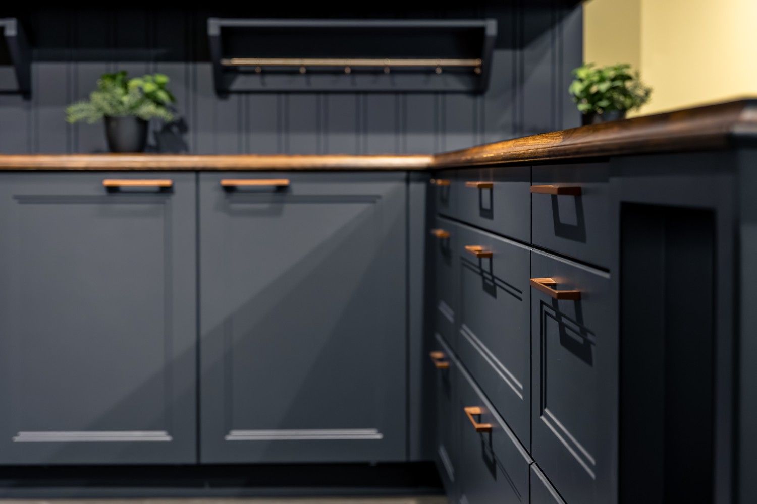 Blue kitchen corner with wooden countertop and copper hardware