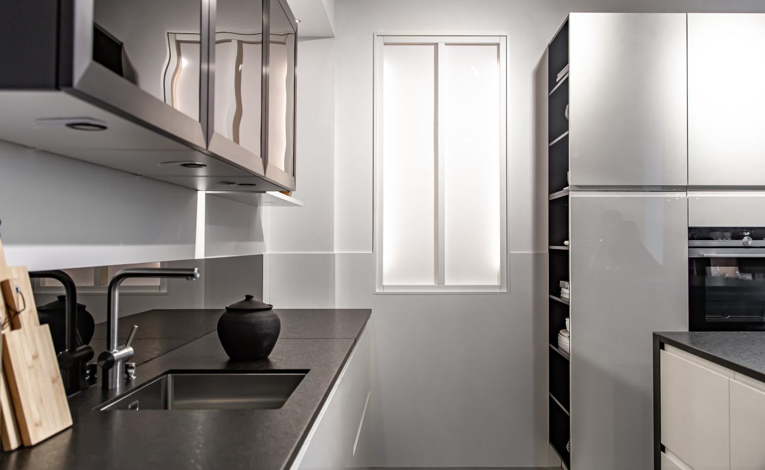 Modern minimalist kitchen with dark countertops and sleek white cabinets